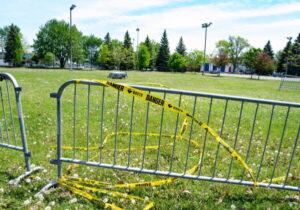 Danger warning tape is wrapped around barriers in the Montreal borough of LaSalle after a toddler died of her injuries when a bouncy castle was swept up by strong winds on Sunday.