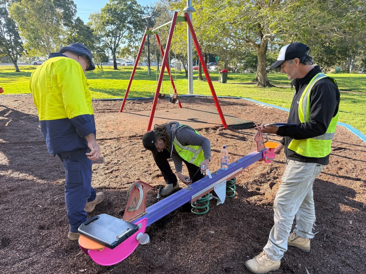Workers inspect playground seesaw