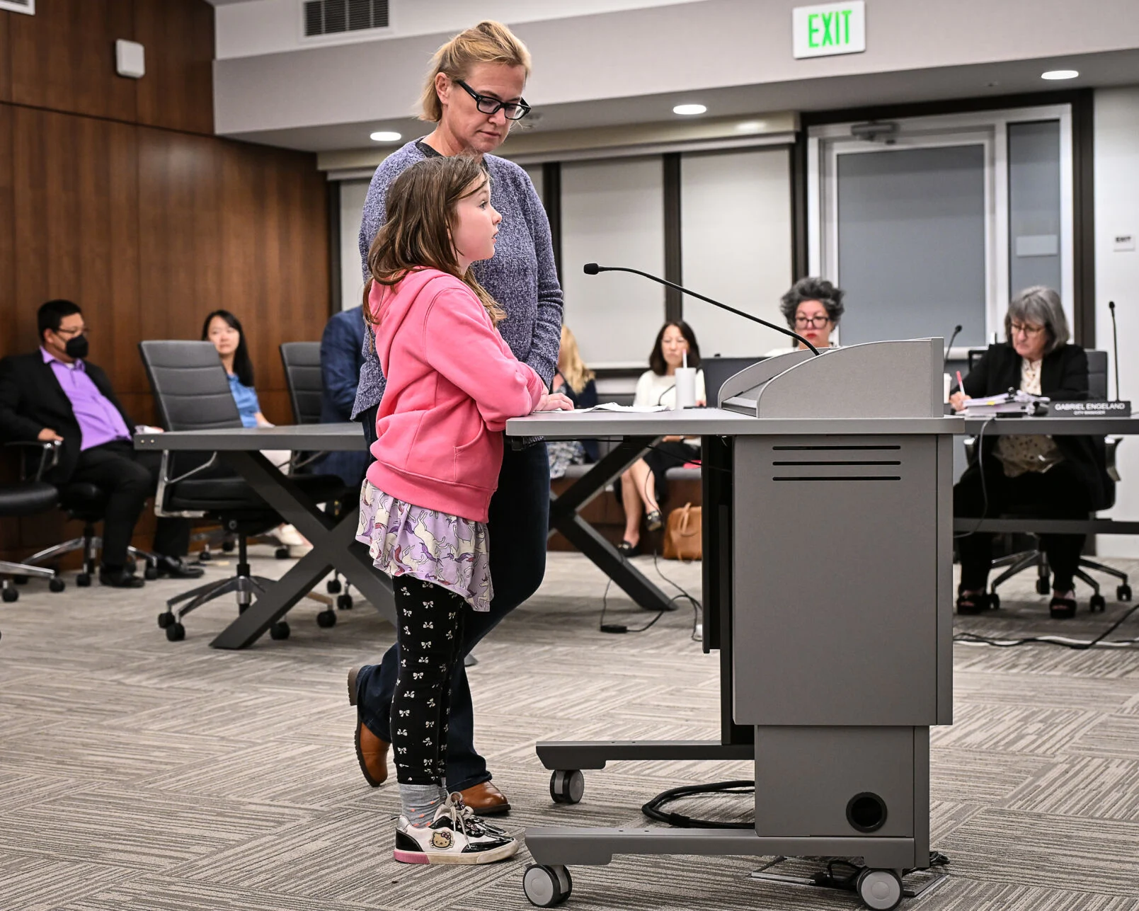 Child speaks at podium with adult
